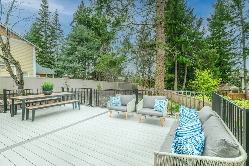 Beautiful residential deck with railing and outdoor seating overlooking a landscaped yard