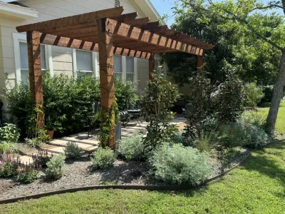 Pergola with concrete paver walkway through outdoor area